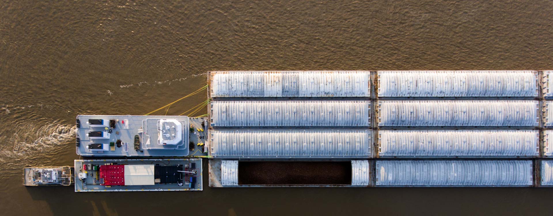 An overhead view of cargo containers on a concrete structure surrounded by water.