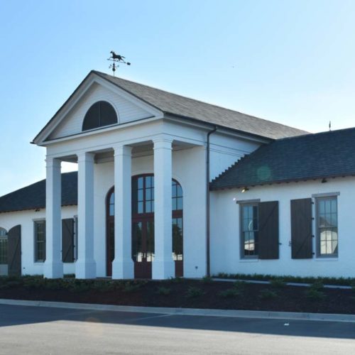 A front view of the building for the hangar and terminal. It's a white building with four columns in front and a grey roof.