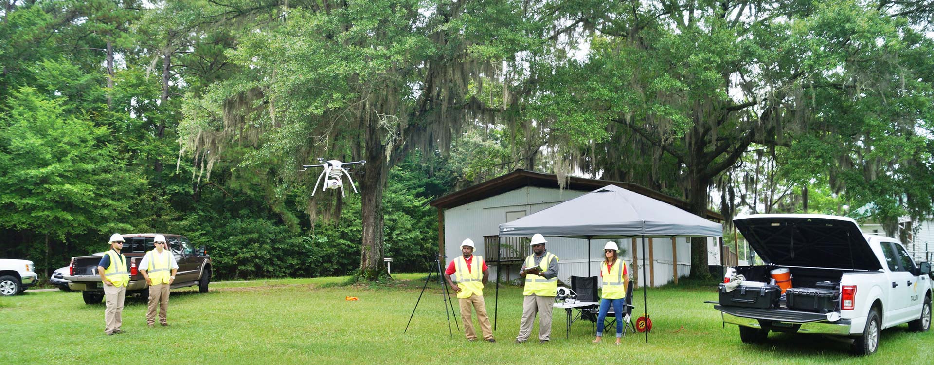 Construction workers operating a drone outdoors.