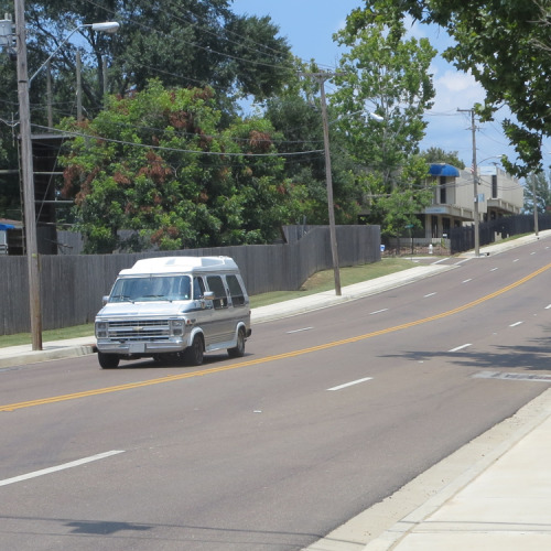 View of a car driving on a freshly paved Jackson street.